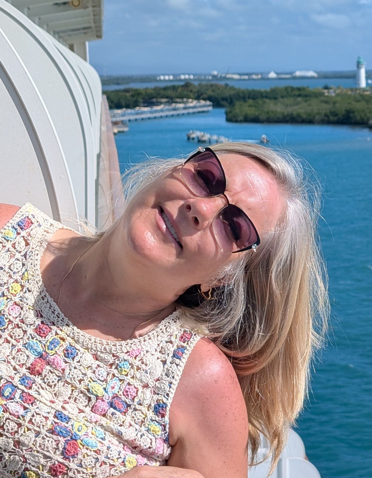 Tanya in sunglasses on a deck over the water